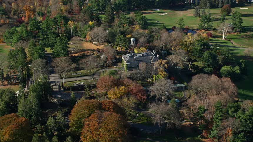 A mansion in an area with a huge yard of grass and trees