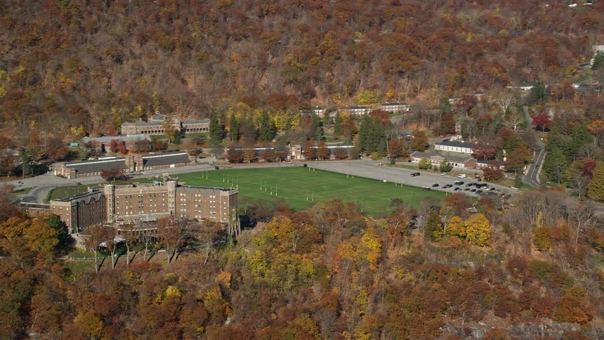 Aerial of a suburban neighborhood surrounded by forest and mountains during the day
