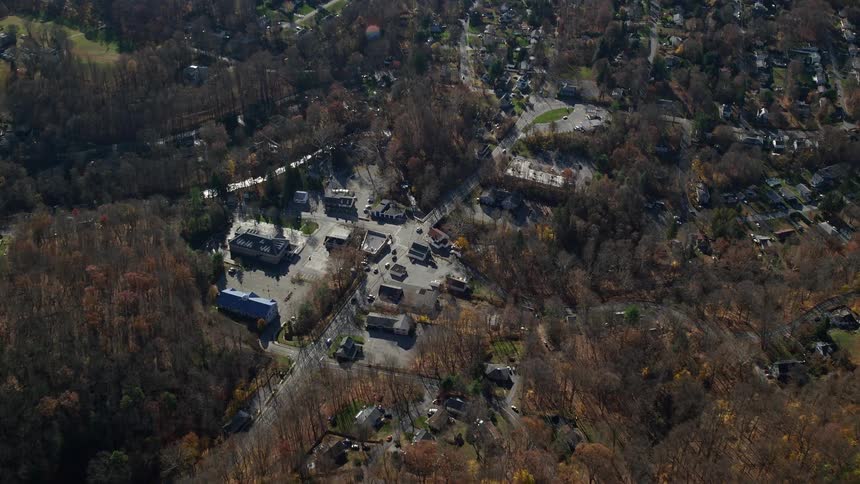 A rural town with a few cars passing by on the highway