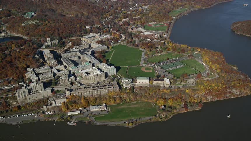 Aerial view of grassy fields and buildings by the sea