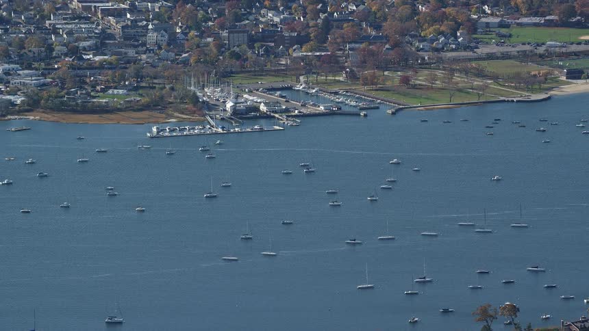 Aerial view of a marina with yachts and in the foreground a residential neighborhood