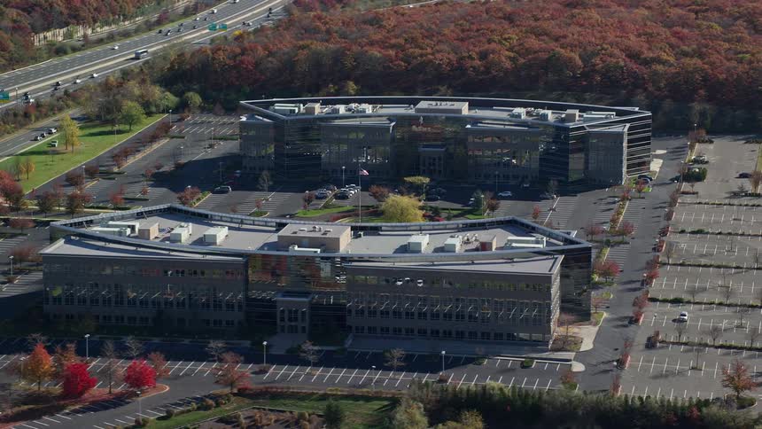 Aerial view of two mirrored blocks of buildings next to a highway