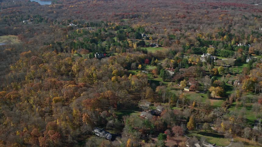 Aerial of a suburban neighborhood with lakes and forest during the day