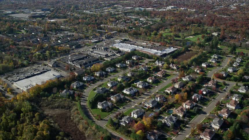 Aerial view of the suburbs with several houses and trees lining the streets