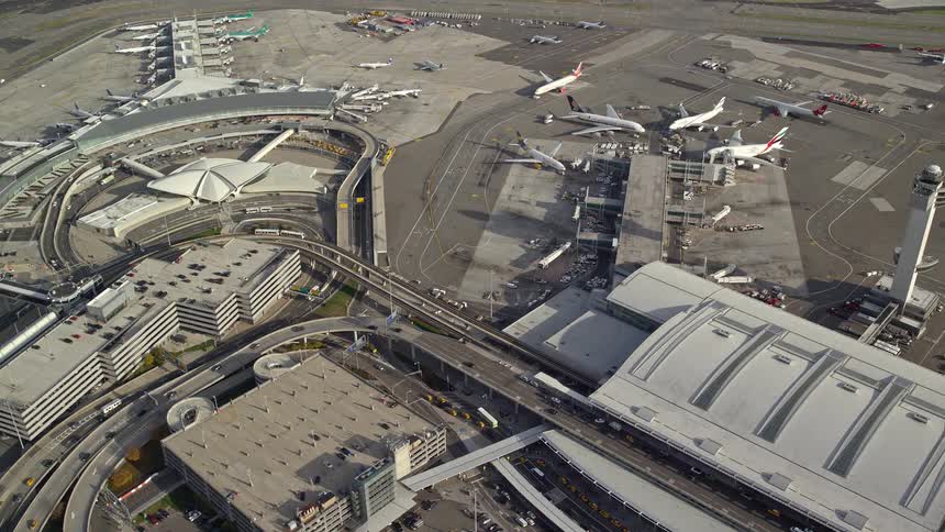 An airport with planes parked and a busy road closeby