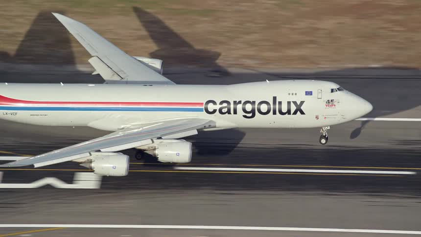 An aerial view of a cargo plane landing on the runway at the airport