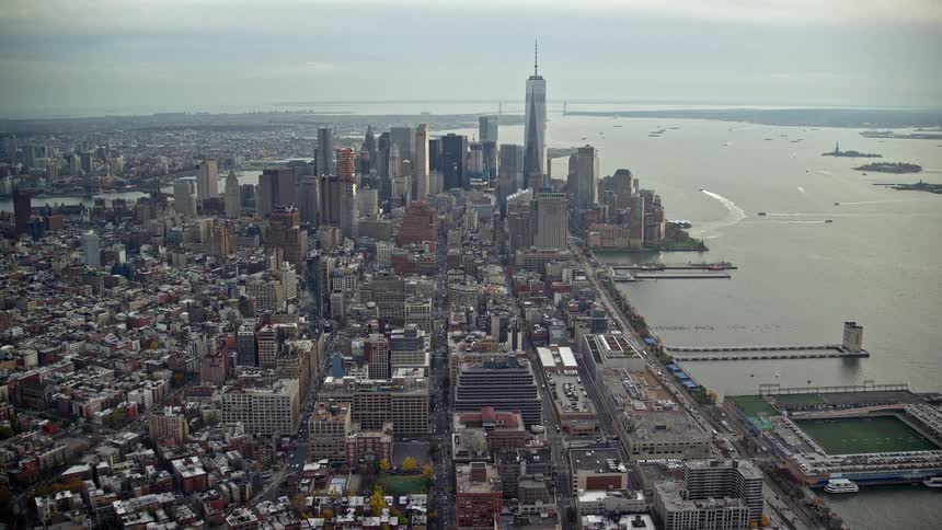 A city close to shore has lots of modern buildings including skyscrapers