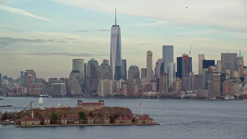An island with many houses in the middle of the sea and behind a metropolitan city huge buildings