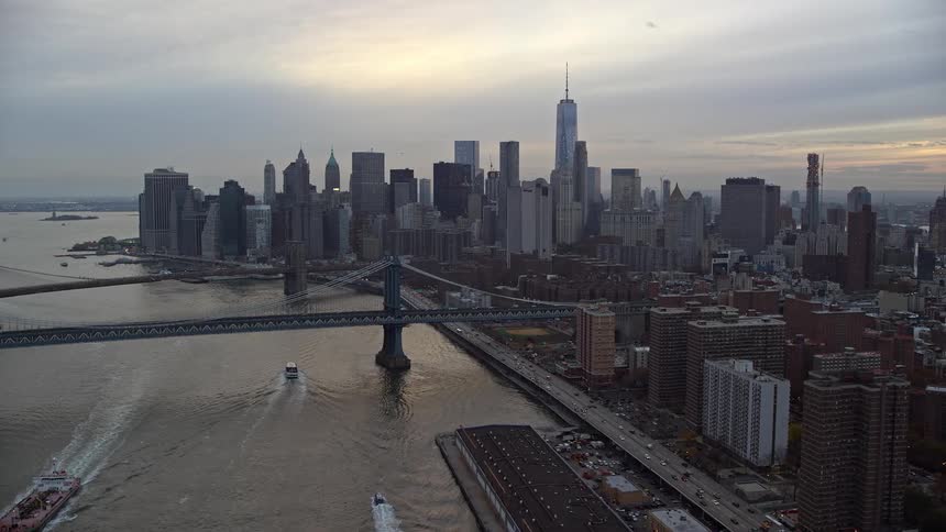 A metropolitan region with several tall buildings and a bridge that crosses the sea
