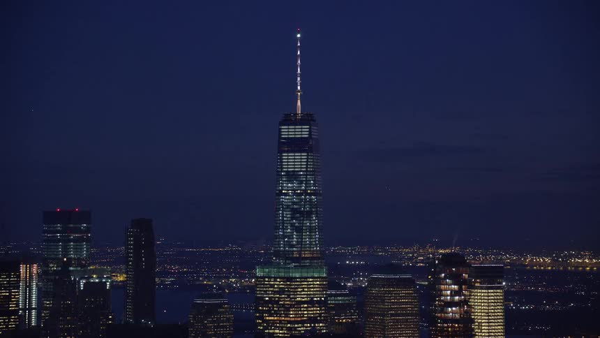 A big tower in a city at night and the tower lights are on
