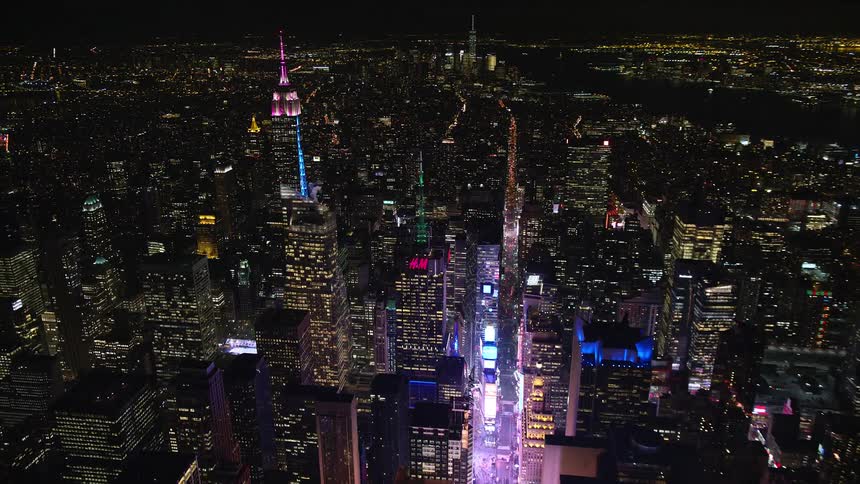 Aerial of the new york downtown skyline with times square and the empire state building lite brightly at night