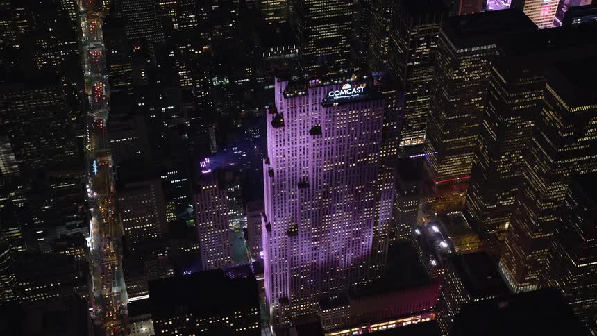 Skyline of the comcast building lit up purple at night