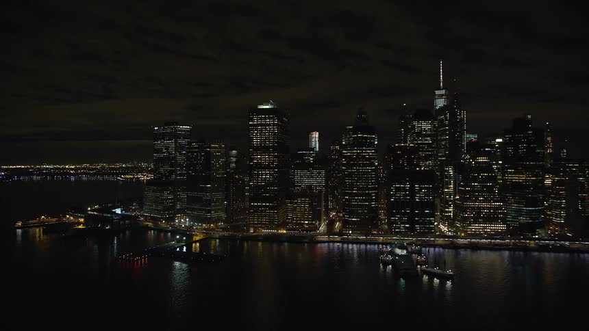 Aerial view of a metropolis at night with skyscrapers by the seaside