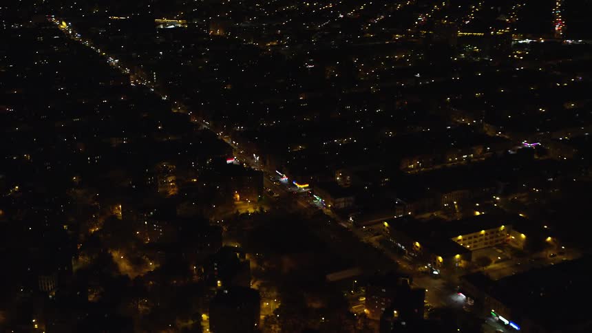 Aerial of buildings and moving cars in a metropolitan area at night