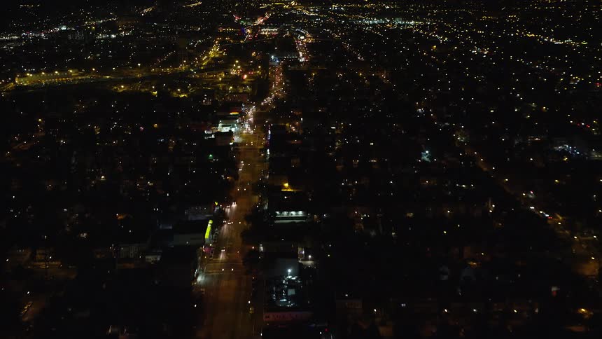 Aerial of buildings and moving cars in a city at night
