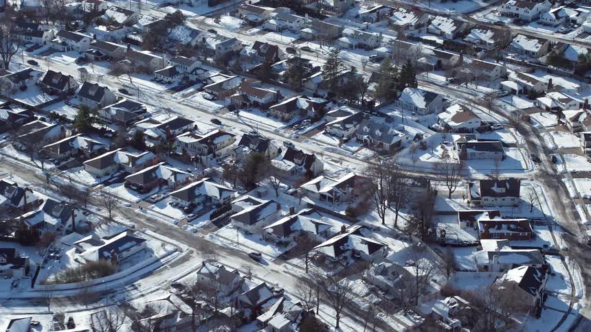 Aerial view of a residential neighborhood with houses covered in snow during winter