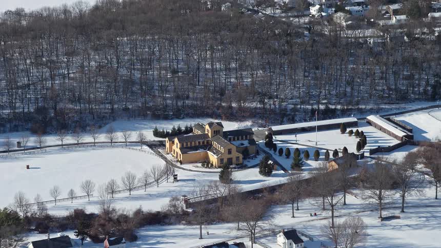 A building in a sub urban setting surrounded by snow as its winter