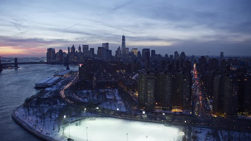 Aerial panorama of a metropolitan city with waterfront bridges under a late afternoon sky