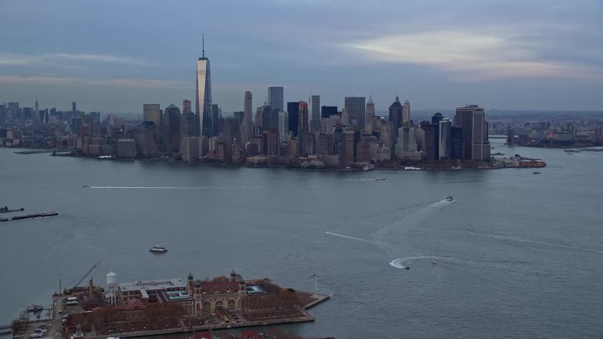 A city skyline surrounded by a river as boats move around in the water