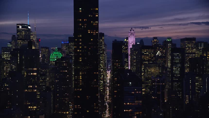 Skyline of a city with illuminated skyscrapers during dusk