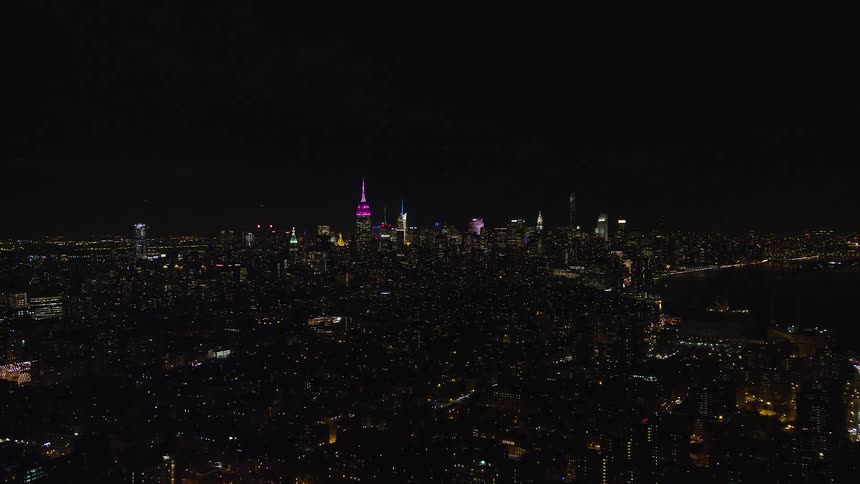 A metropolitan city at night with building lights on