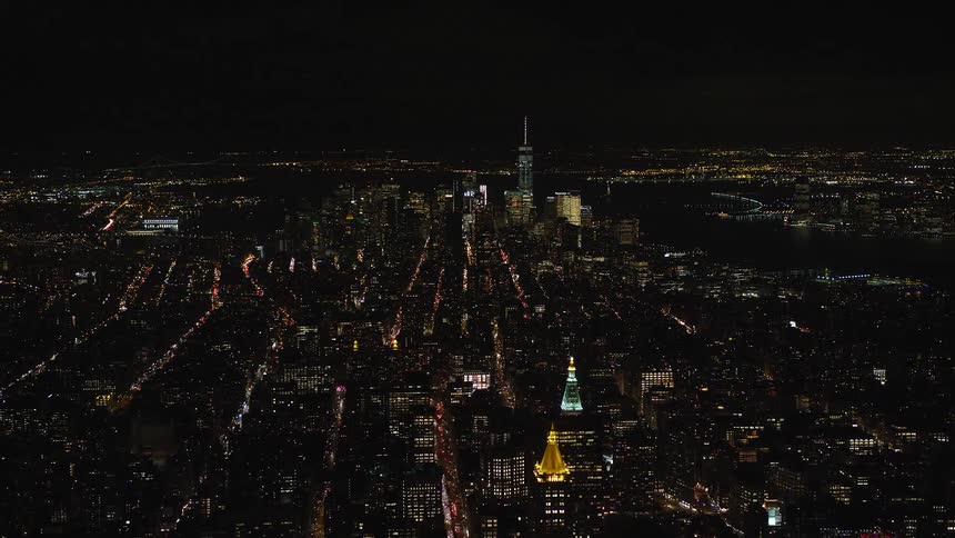 Aerial view of a city lit up at night with a pitch black sky