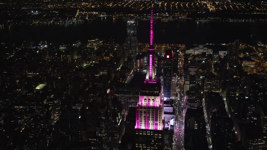 Aerial panorama of a skyscraper with pink lights in a metropolitan city at night