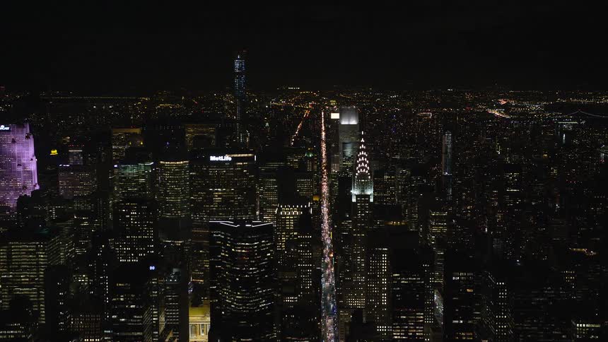 Skyline of a city with glass towers illuminated at night