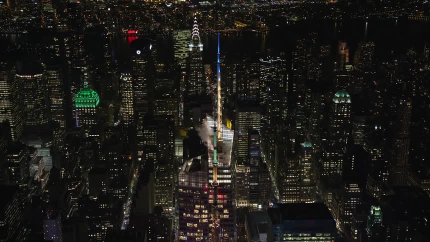 A drone in the air captures a huge lit up city at night