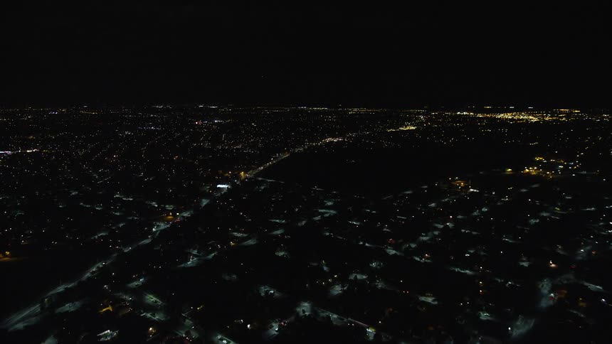 Darkness is upon the city as it is night time with faint lights spread across the city
