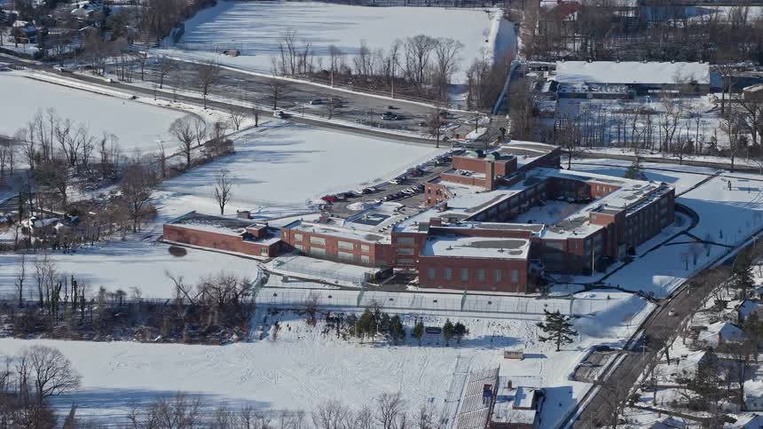 Aerial of a snowy building in an urban neighborhood