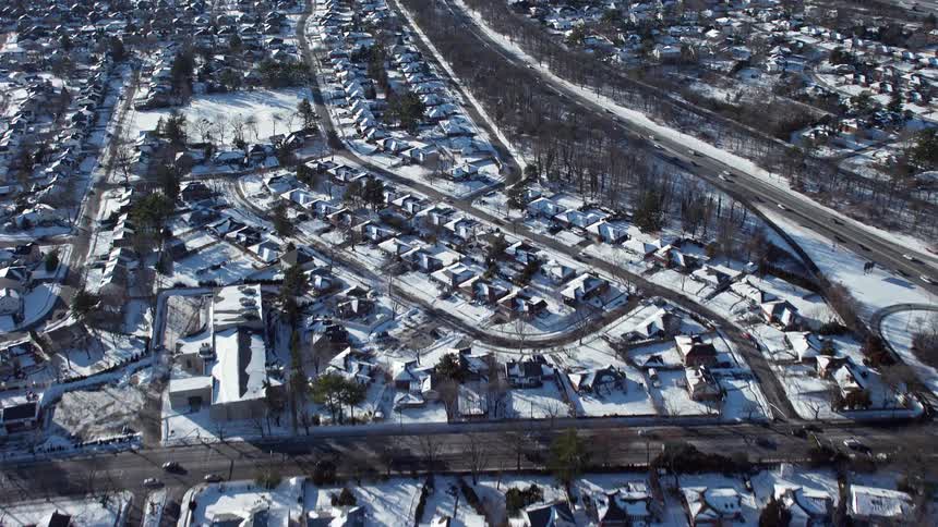 Aerial panorama of an urban city covered in snow with central highways
