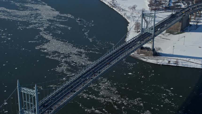 Aerial view of a bridge crossing a lake amidst cities