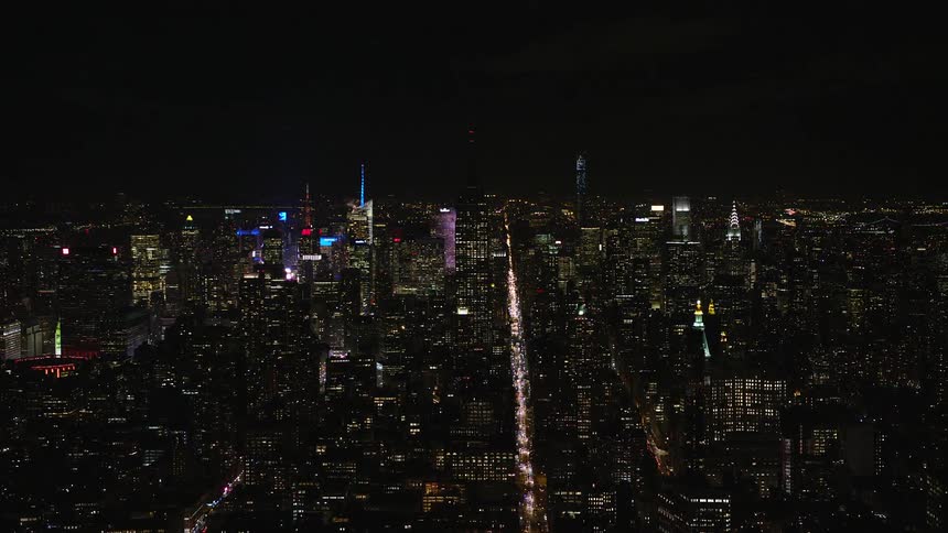 Aerial panorama of a metropolis at night with highways illuminated by vehicles