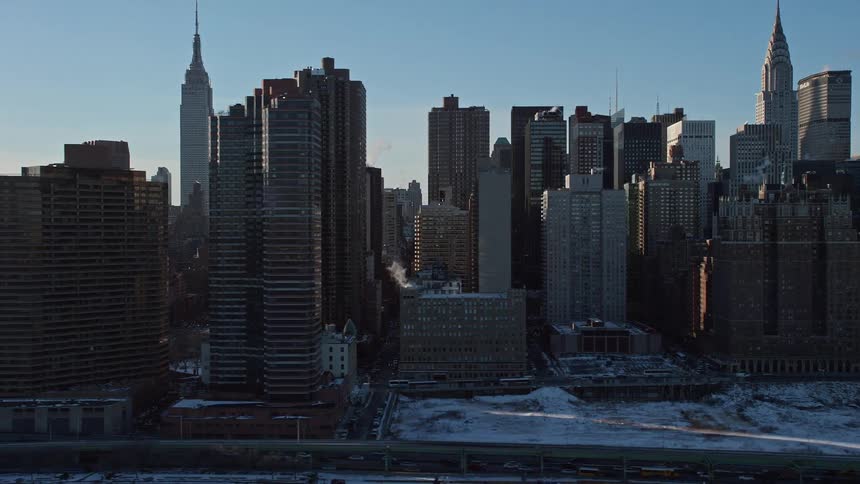 View of giant buildings in a metropolis by the seaside under a morning sky
