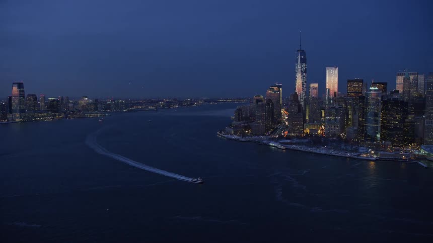 At shore we can see a city view at night with skyscrapers