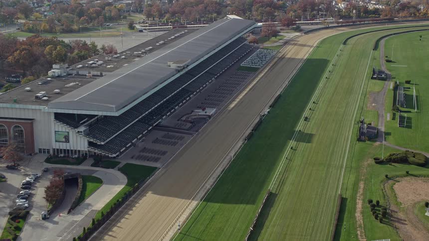 A race track stadium with green field and a podium