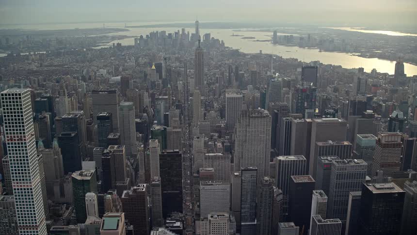 Aerial of downtown skyscrapers towering over surrounding buildings a few blocks from the waterfront on a foggy day