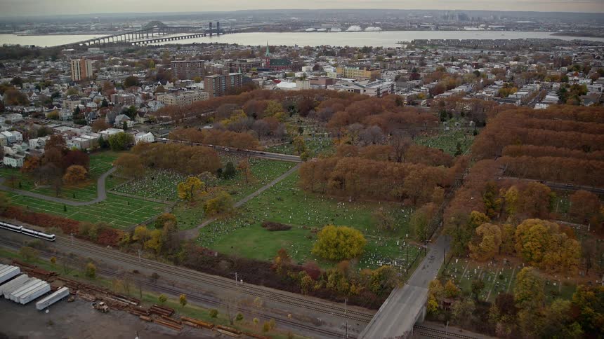 Aerial panorama of a cemetery amidst a highway in the city