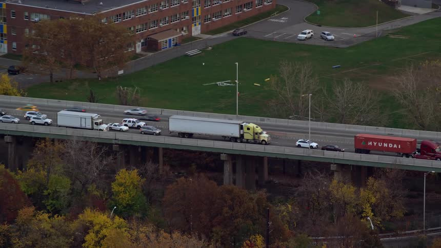 Aerial panorama of a highway with trucks and cars