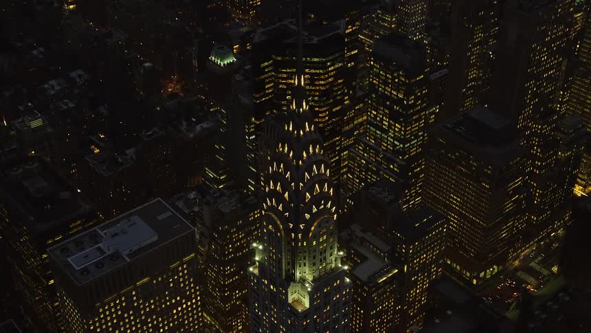 Aerial view of a modern skyscraper in the midst of a seaside metropolis at night