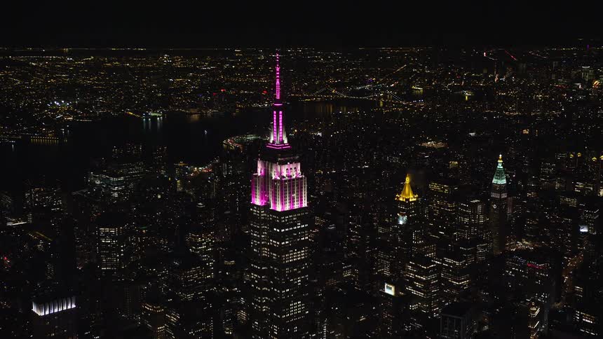 Empire state building with pink lighting in new york at night