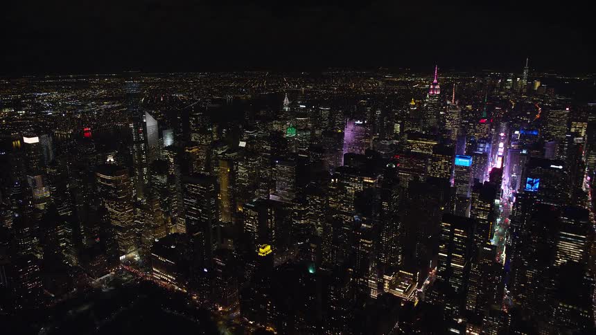 A city at night filled with skyscrapers and towers as light from the buildings shines through the night