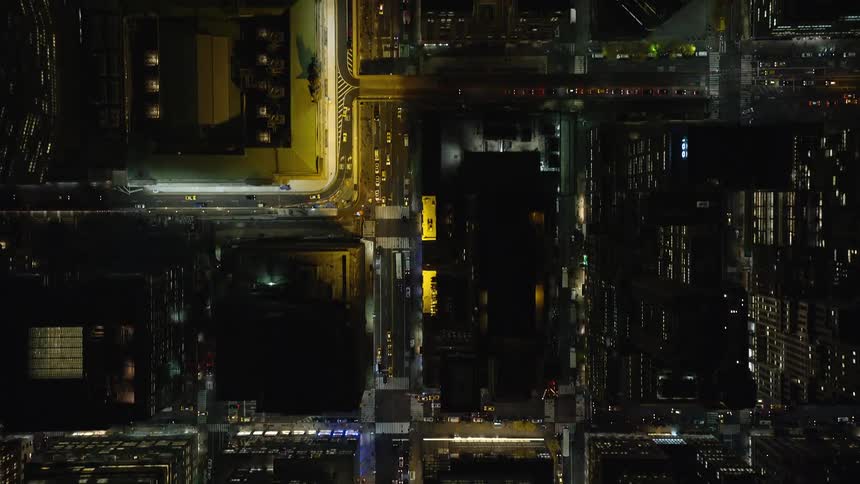 An aerial view of a night citys buildings and illuminated streets
