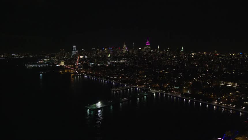 Aerial view of a stadium on the sea in a metropolis by the waterfront at night