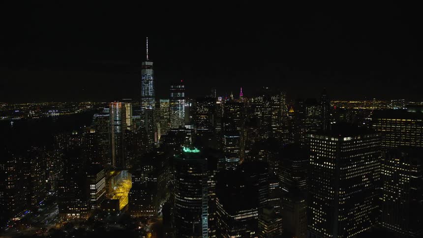 Aerial view of a metropolis at night with skyscrapers by the seaside