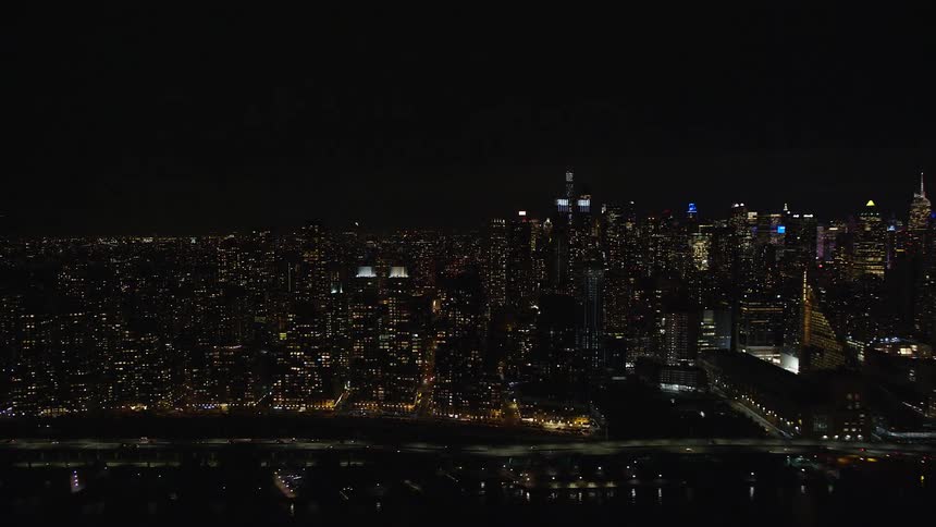 Aerial view of a large metropolis by the sea at night