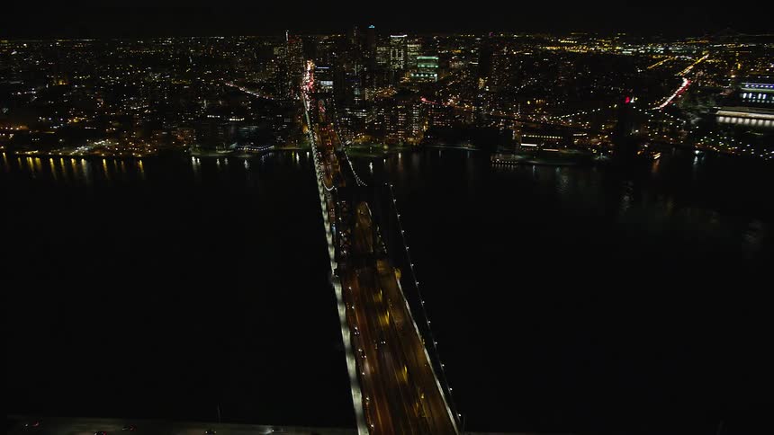 Aerial panorama of a bridge under the sea connecting a metropolis at night