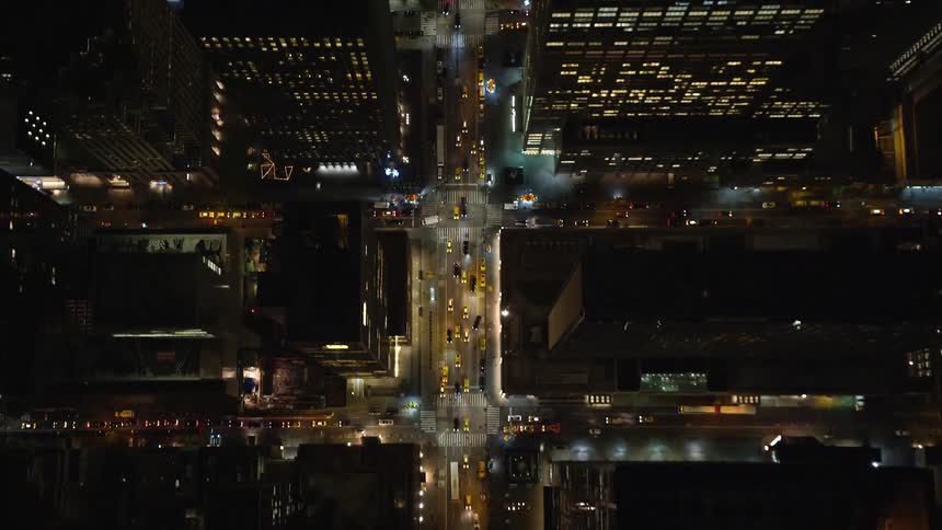 Aerial of buildings and moving cars in a city at night