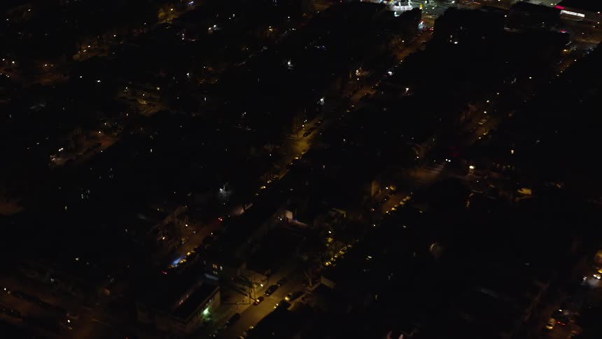 A residential area of a city that is illuminated by street lights at night